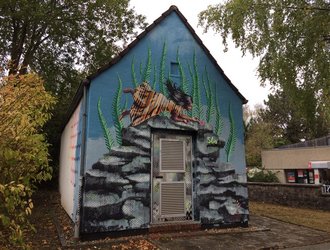 Stree Art Motiv schwebende Frau auf Felssteinen auf STAWAG Trafostation in Aachen