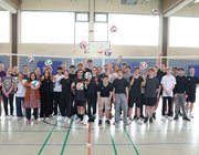 Gruppenbild der Schüler:innen des Gymnasiums in Herzogenrath mit 2 Ladies in Black Spielerinnen und zwei Lehrern in Sporthalle