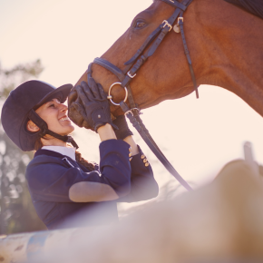 Reiterin küsst Pferd oberhalb der Nüstern