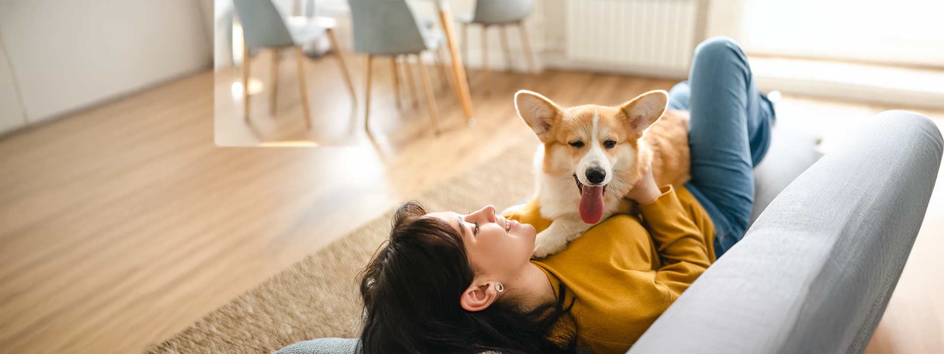 Frau liegt mit Hund auf Sofa